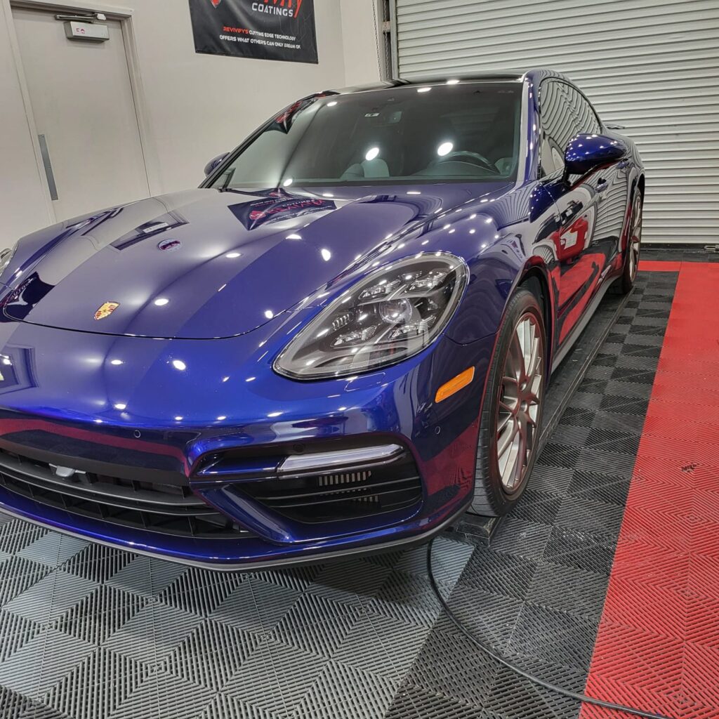Blue Porsche sitting in garage with checkered floors.